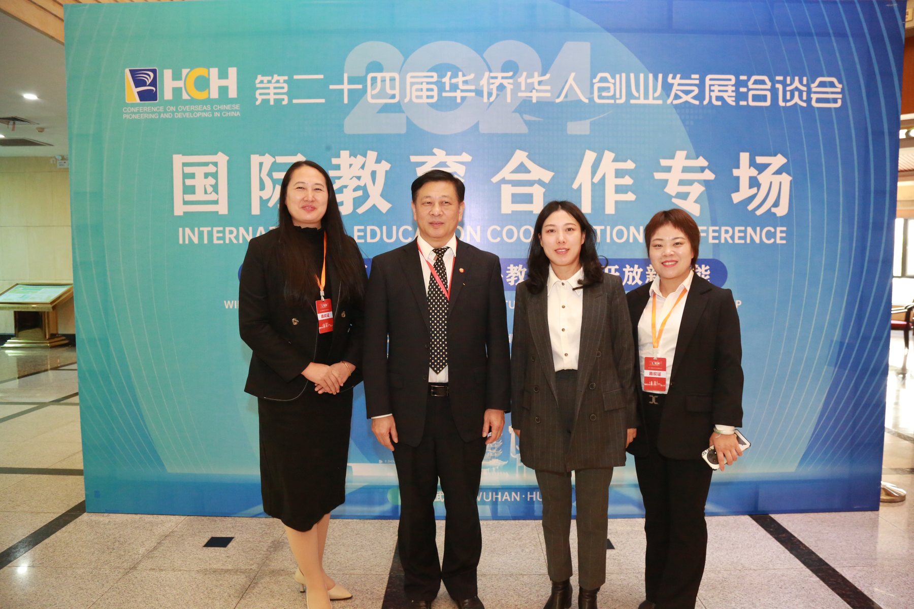 参会嘉宾在大会主题背景板前合影